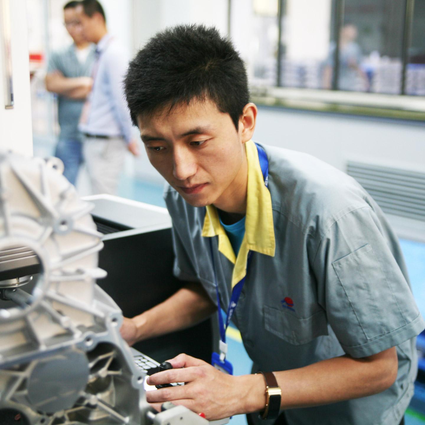 A metrology technician at a measuring machine at Xusheng.