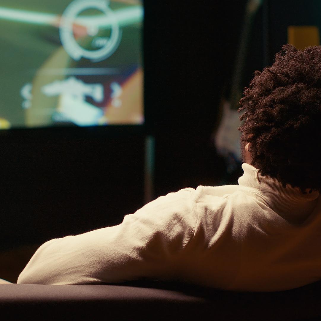 A man playing a video game on a big TV screen.