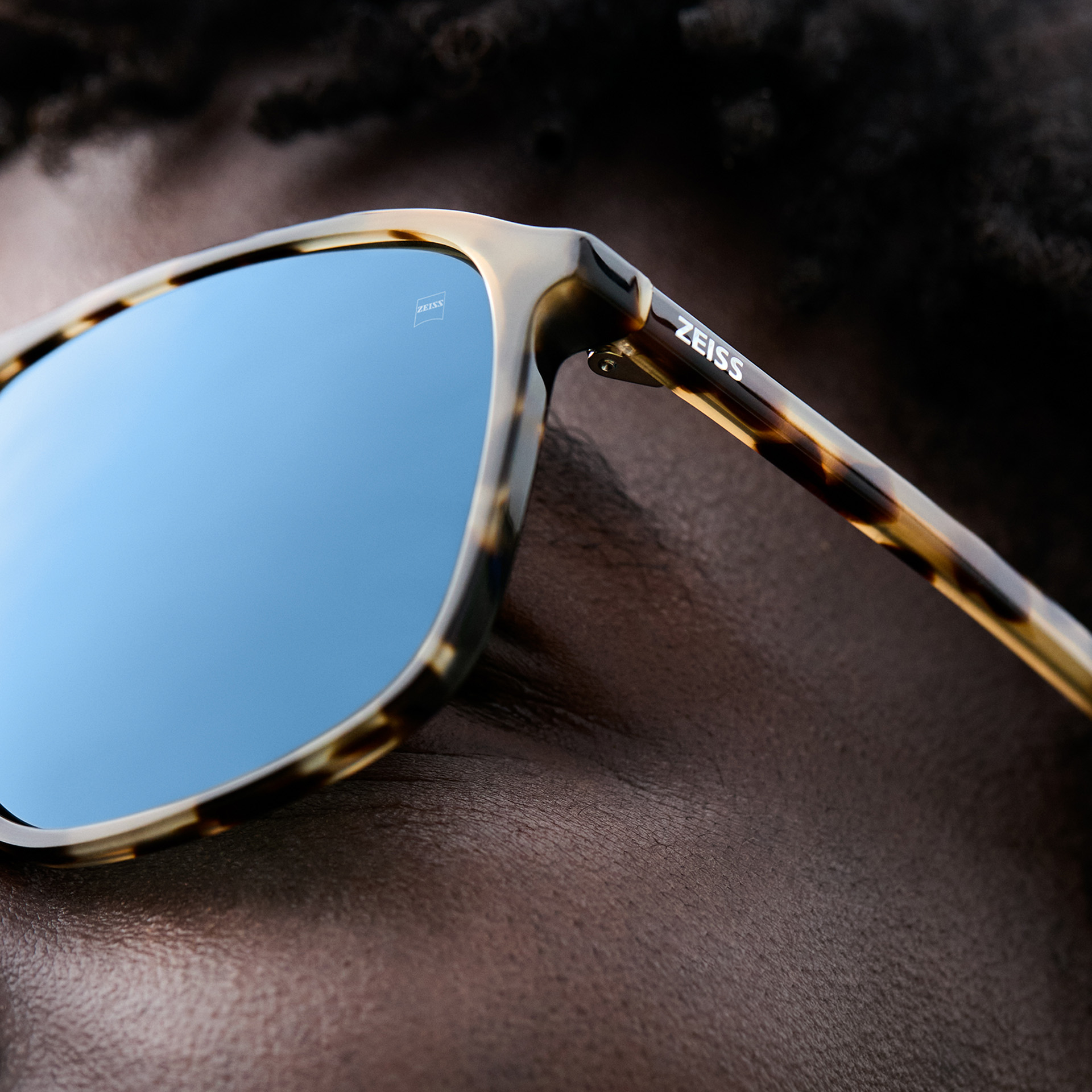 Sunglasses with grey tint lies on a clean, light surface.