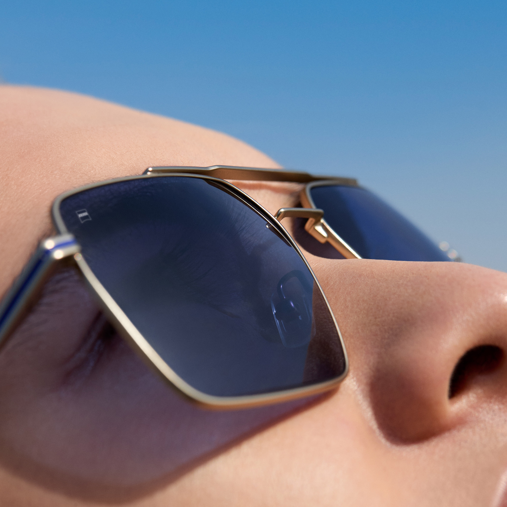 Extraordinary cat eye sunglasses on a white surface with cyan-purple-gradient tint