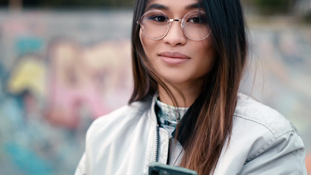 A young woman in a skatepark wearing ZEISS Single Vision SmartLife lenses.